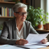 Femme d'environ 60 ans examine des documents de pension dans un bureau
