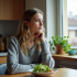 Jeune femme pensive dans une cuisine cosy avec salade